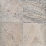 Close-up view of four Travertine - Cappuccino tiles, each displaying distinctive natural patterns in shades of beige, gray, and brown. Arranged in a square formation, these tiles highlight the organic marbled veining and earthy colors characteristic of natural stone.