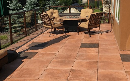 This image depicts a paved balcony space with a luxurious table and chairs.