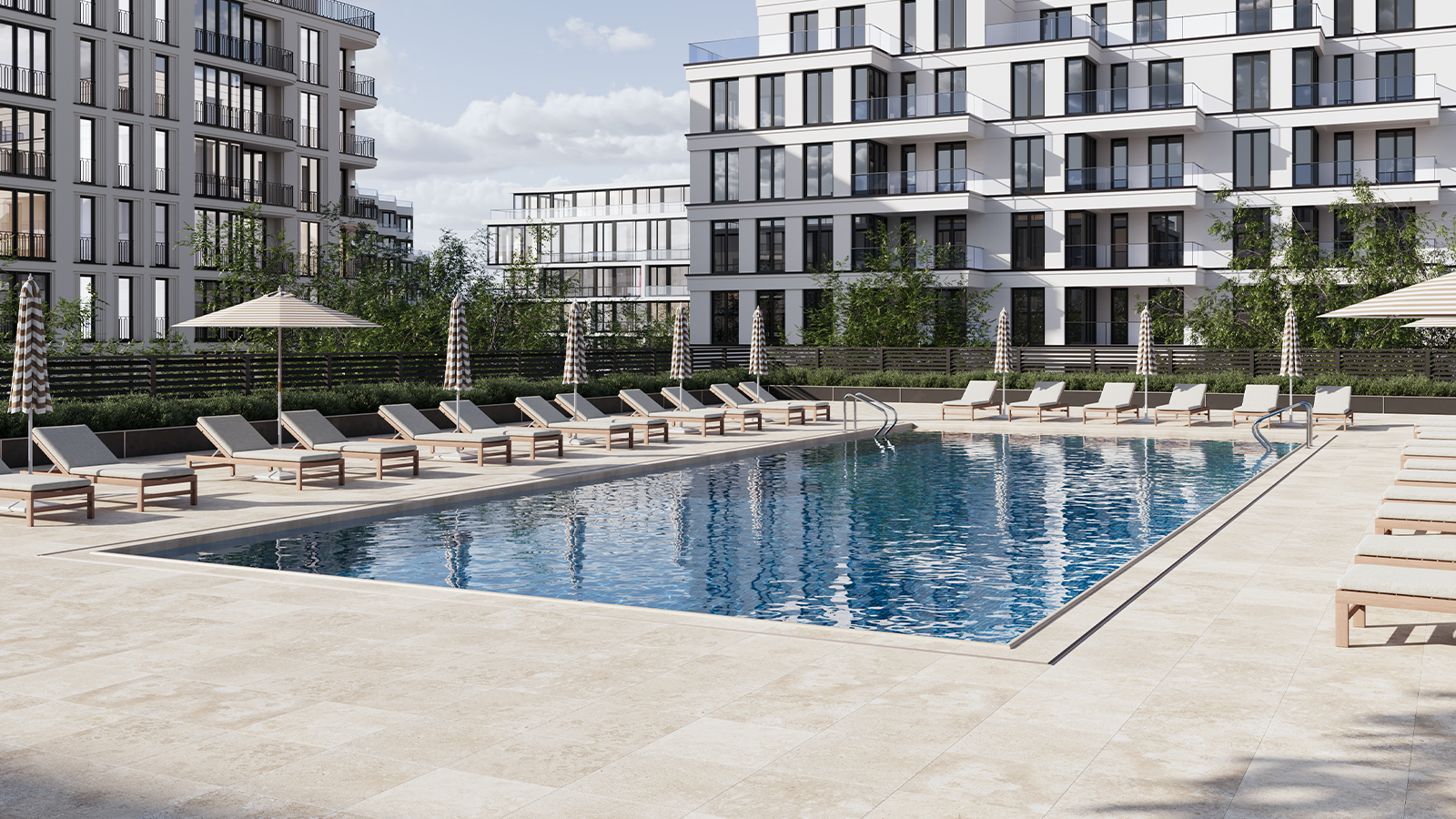 Cream colored travertine porcelain pavers around a multi-family apartment complex pool. 