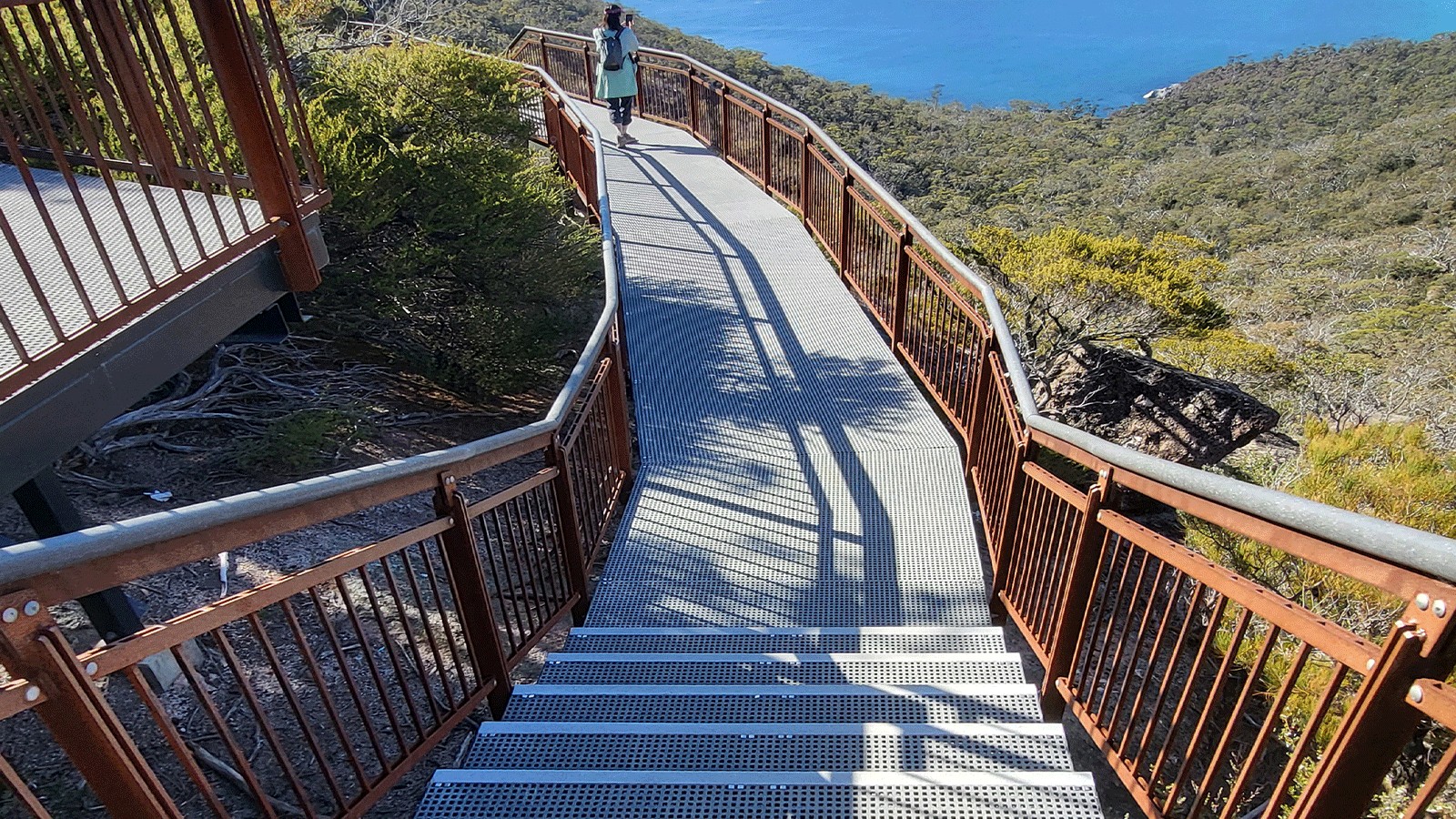 FRP boardwalk with frp stairs in the foreground, overlooking blue ocean.