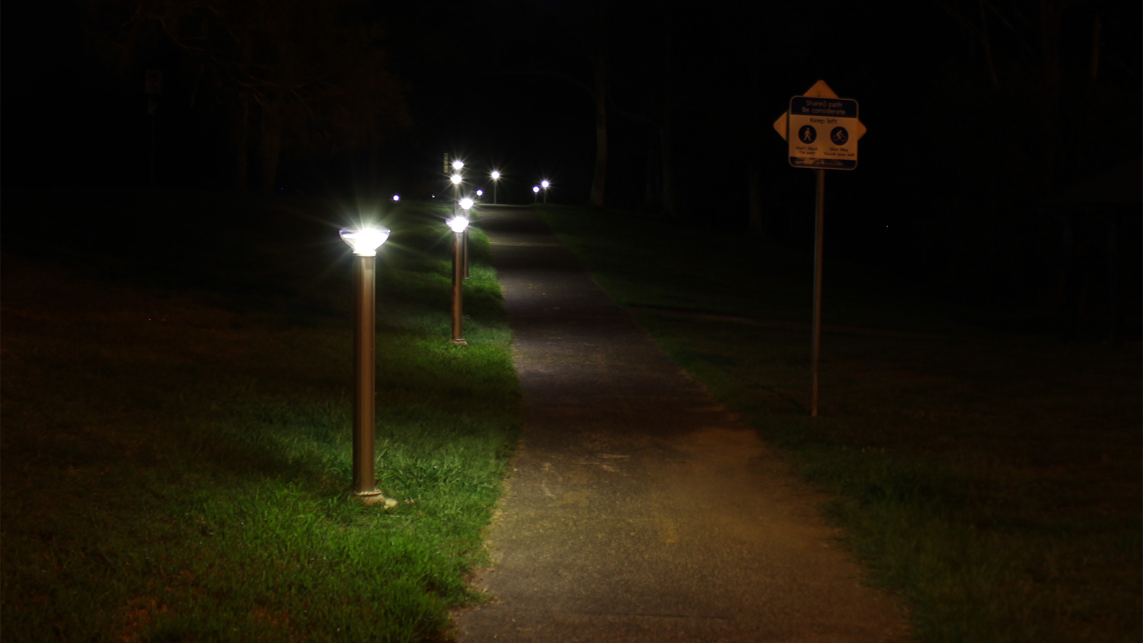 solar bollard lights on a bike path at night. 
