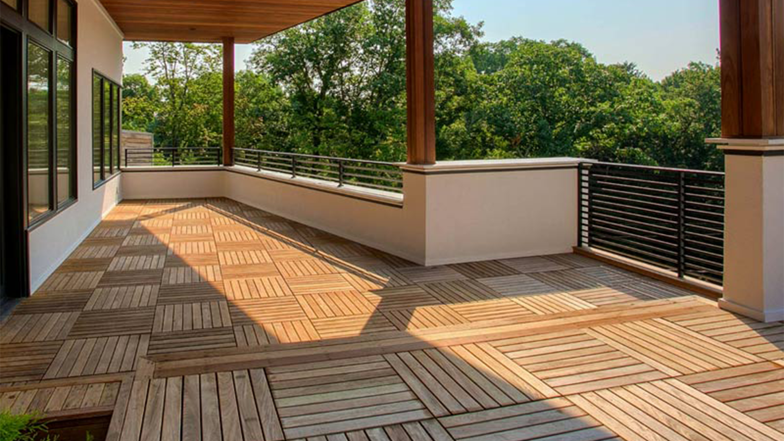 Residential Ipe elevated deck with balcony and trees in background.