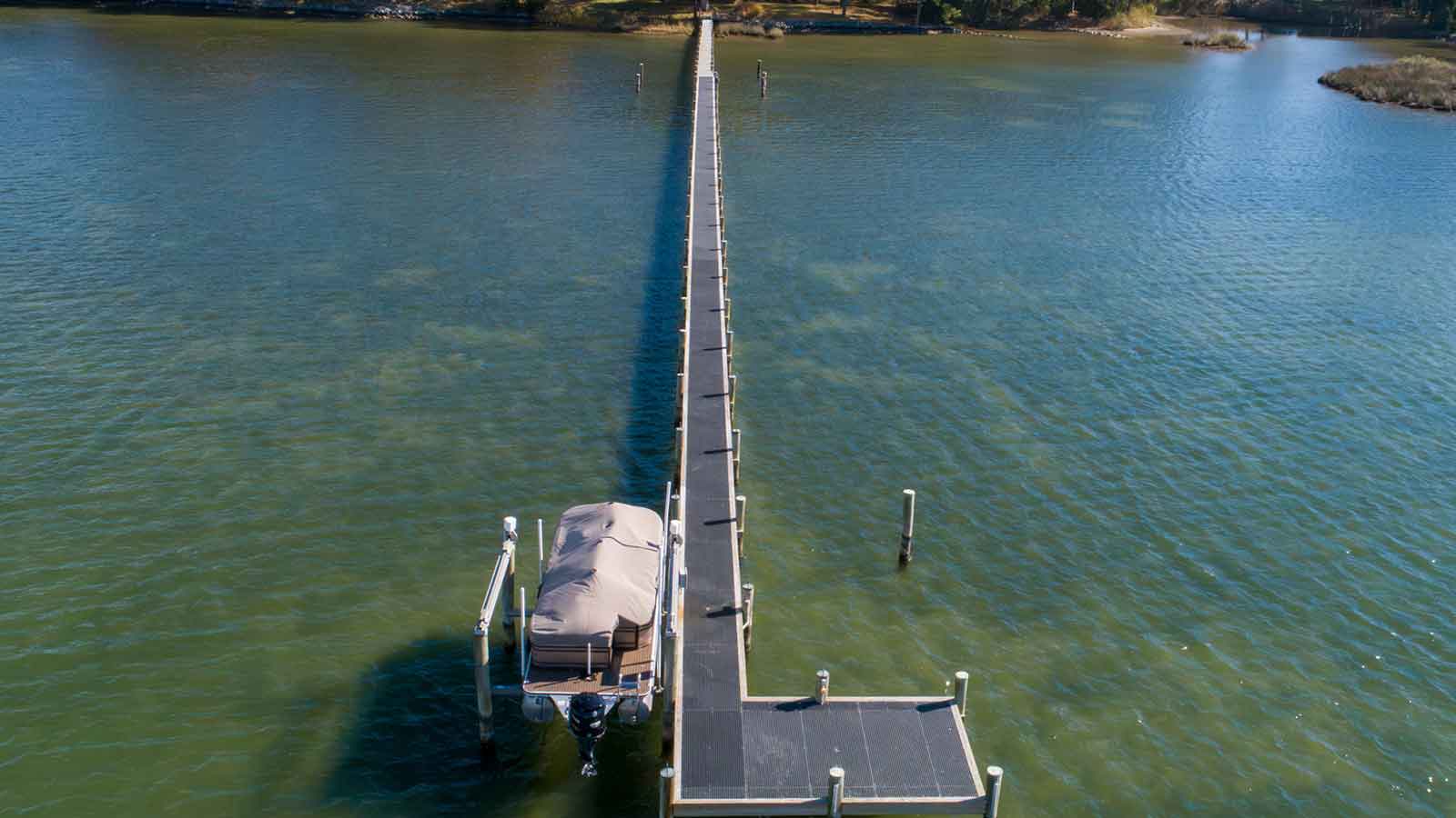 large frp dock or pier with pontoon boat at end of pier.