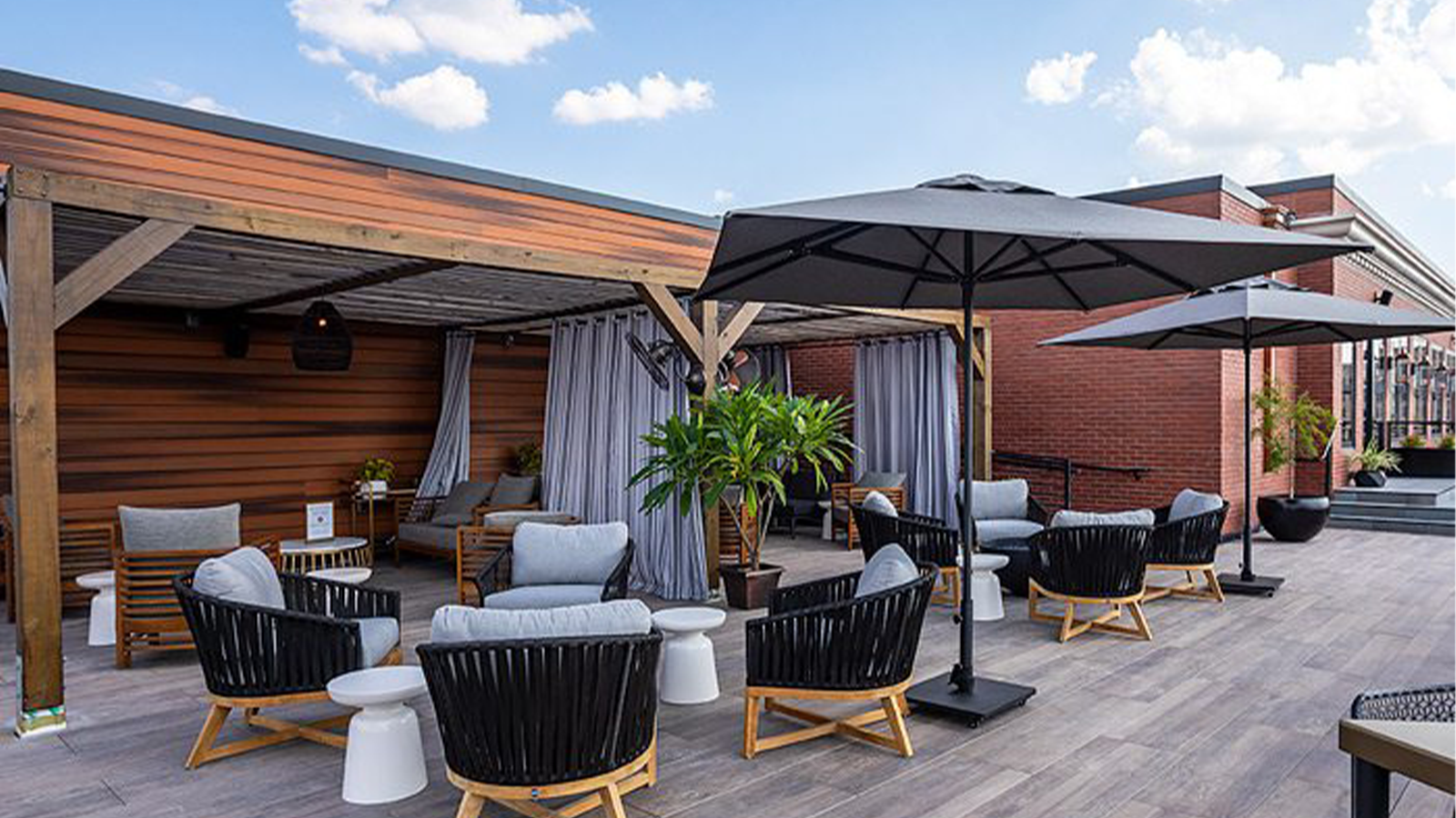 rooftop deck and patio area with wood look porcelain planks, lounge chairs and umbrellas. 