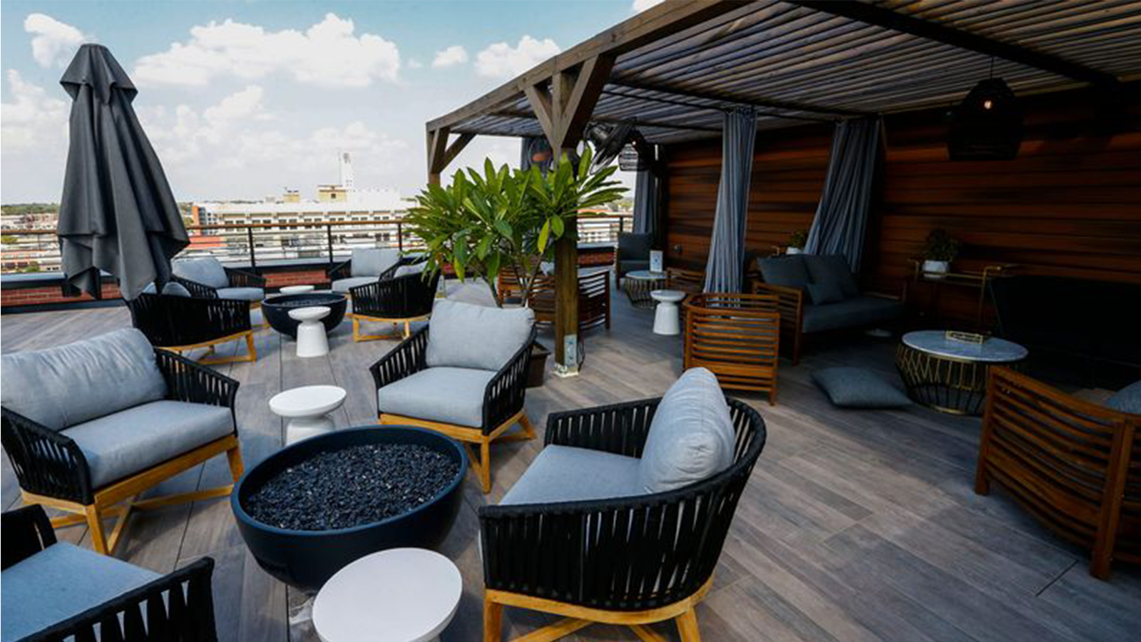 rooftop deck area with wood look porcelain plank flooring, lounge chairs around a pit. 
