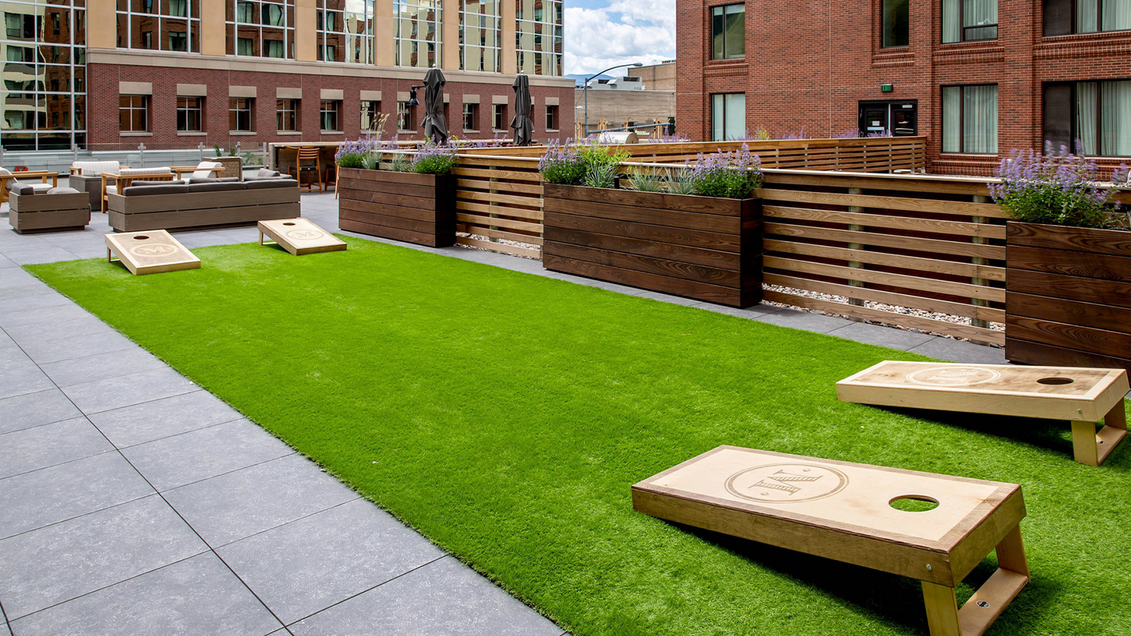 Artificial turf on a roof deck with cornhole set on top. 