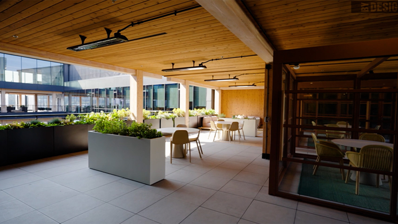porcelain pavers in an indoor outdoor work environment with wood panel ceiling.