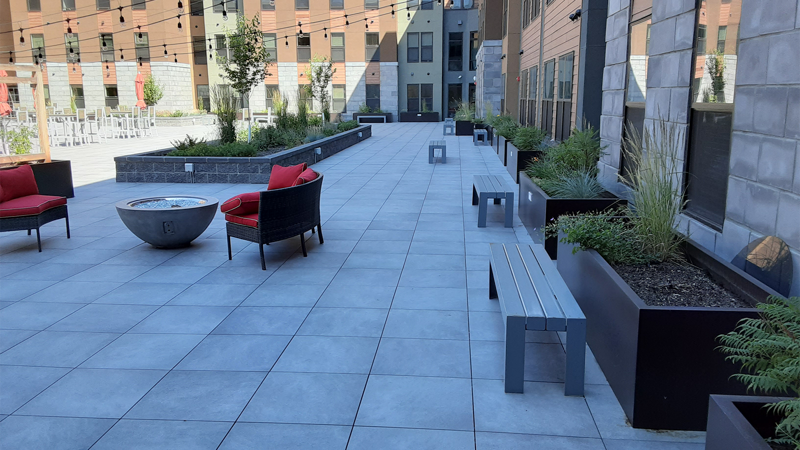 large courtyard at university of montana with bluestone porcelain paver surface, landscaping plants and trees. 