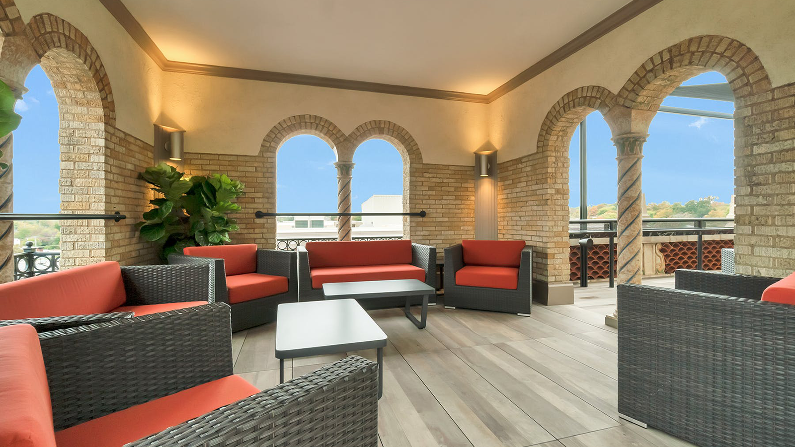 rooftop lounge with red couches and wood look porcelain paver flooring. 