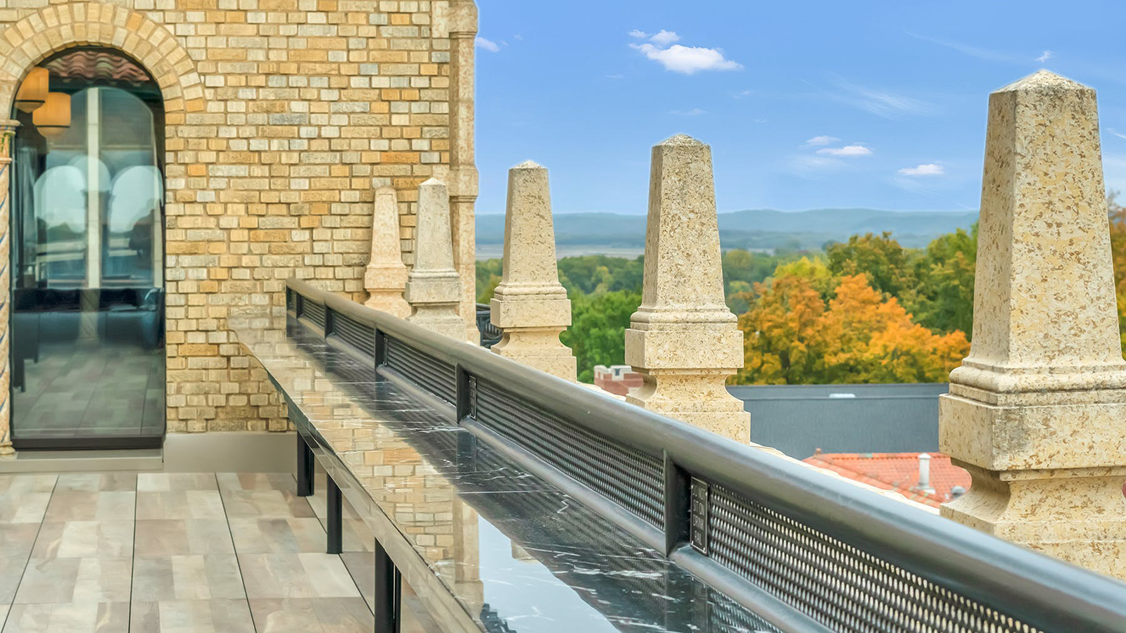 view from the balcony of the marq with wood look porcelain paver floor and blue sky on horizon. 