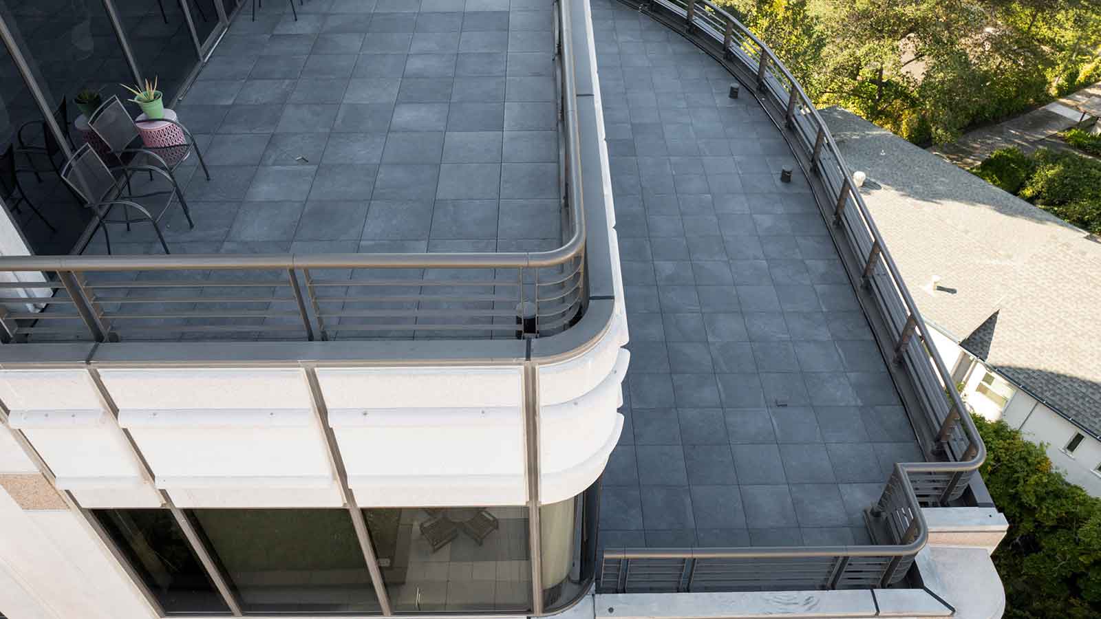 two elevated paver terraces with dark grey porcelain pavers. 