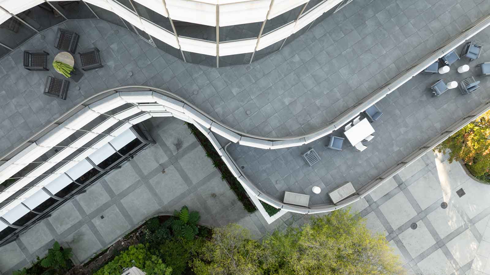 top down view of two terraces with dark porcelain pavers, chairs and tables.