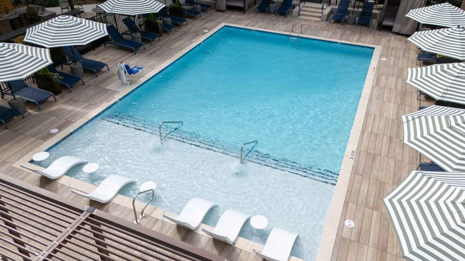 wood look porcelain planks around a pool.