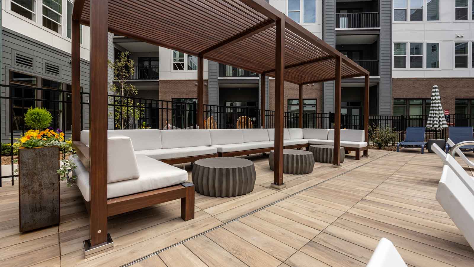 wood look porcelain plank surface on with white pool and patio furniture with small tables