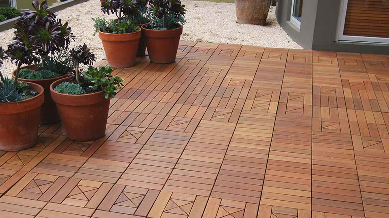 residential ipe interlocking tile patio with potted plants on the perimeter. 