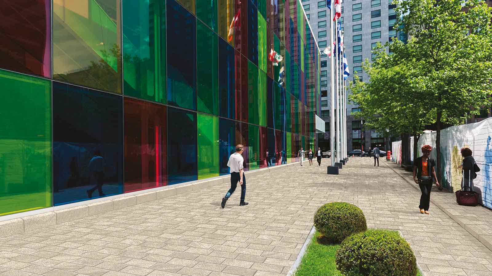 man walking on cream colored porcelain permeable pavers in urban plaza