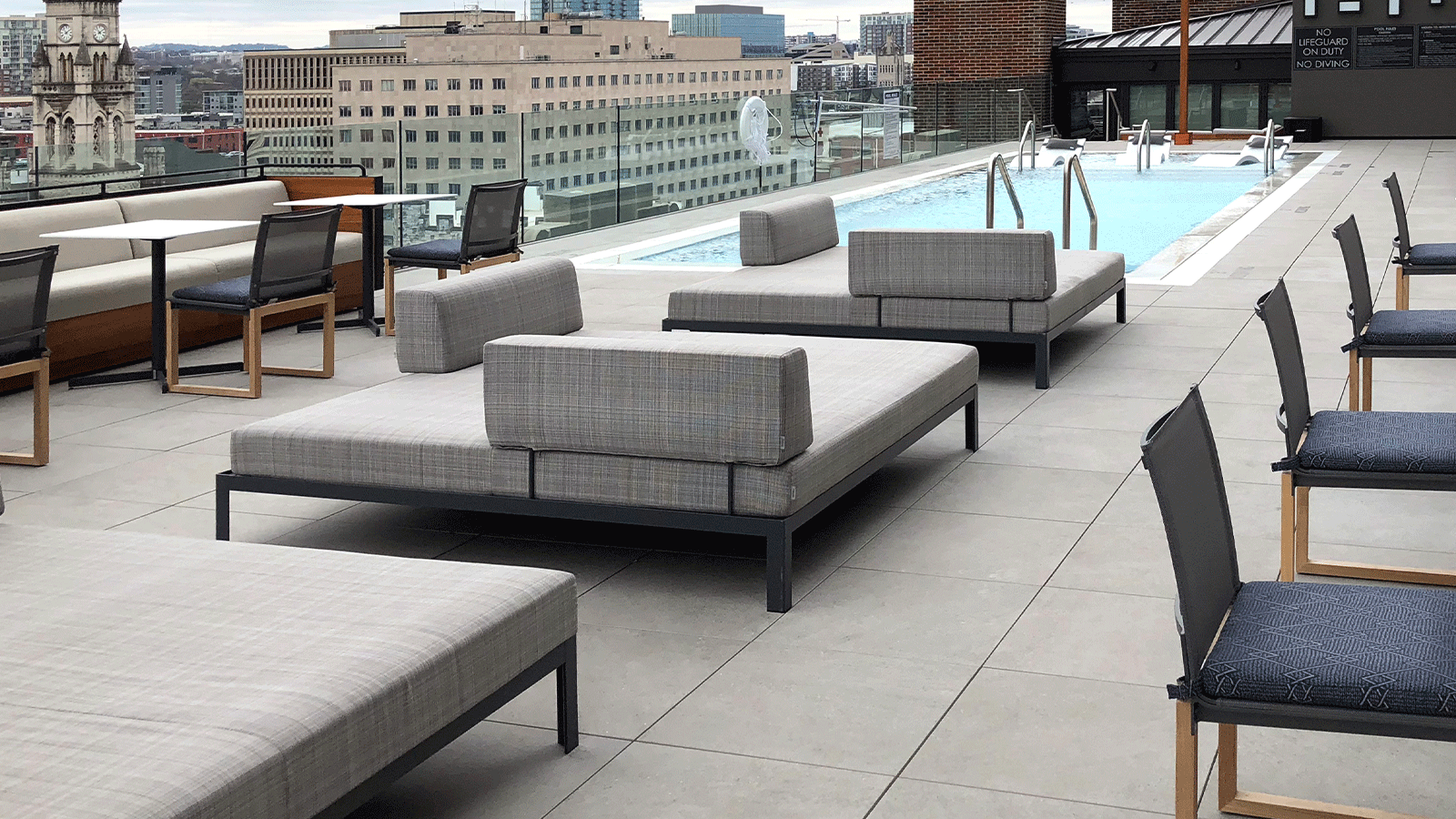 rooftop pool at james robertson hotel with lounge chairs and city view