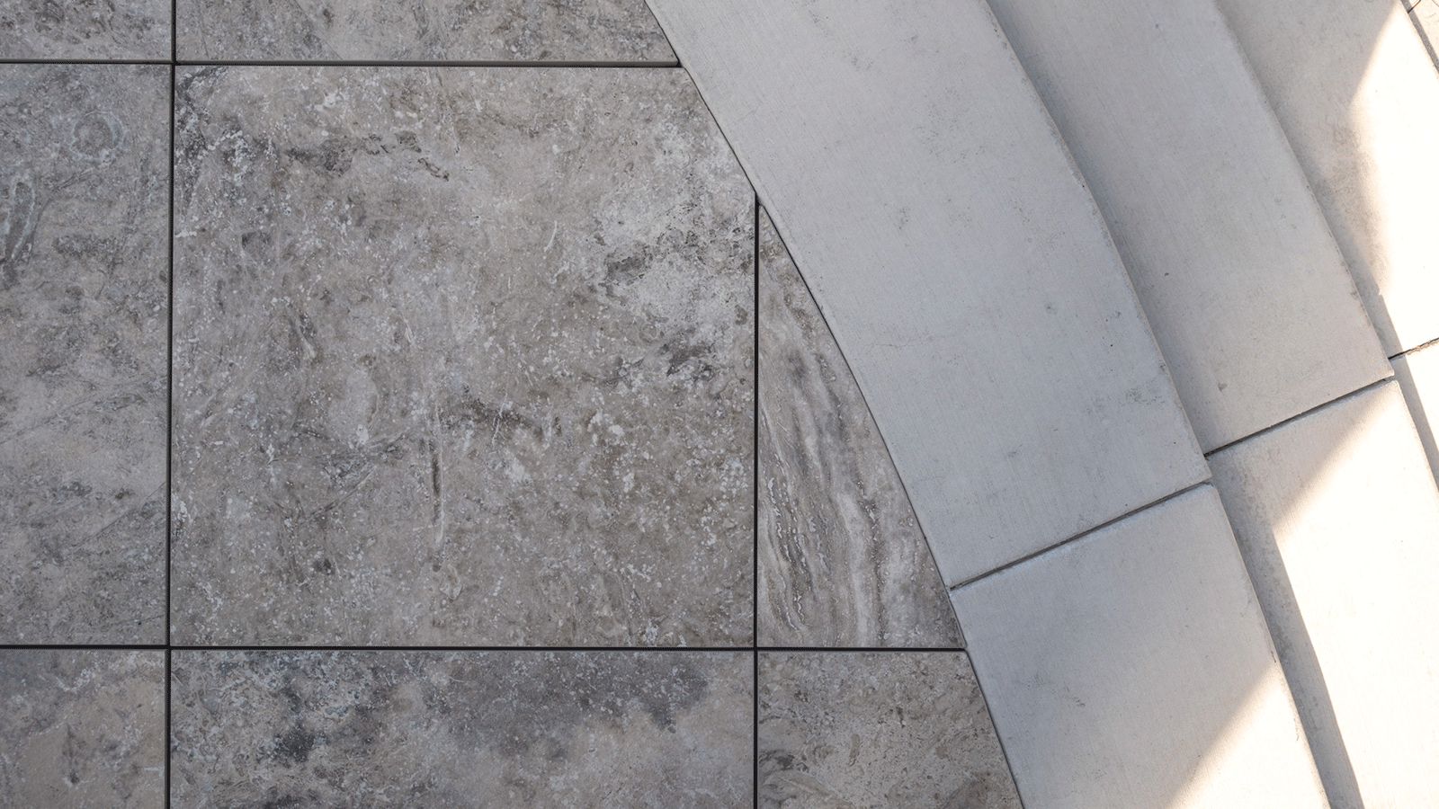 close up view of cream tan colored porcelain paver cut to fit rounded edge.