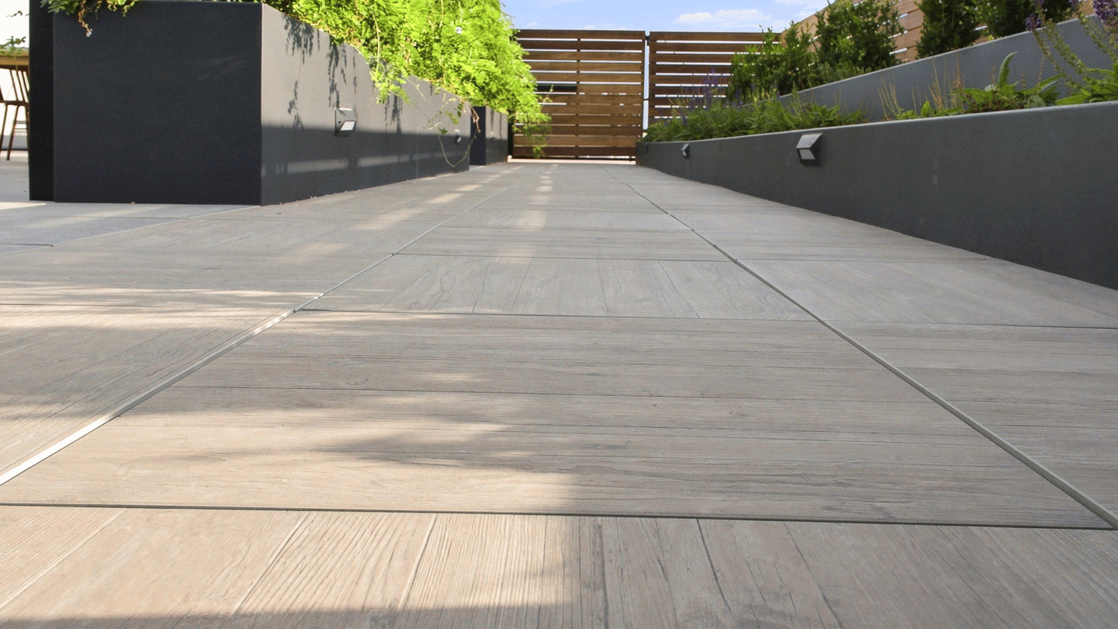 ground level view of wood look porcelain paver on a roof deck.