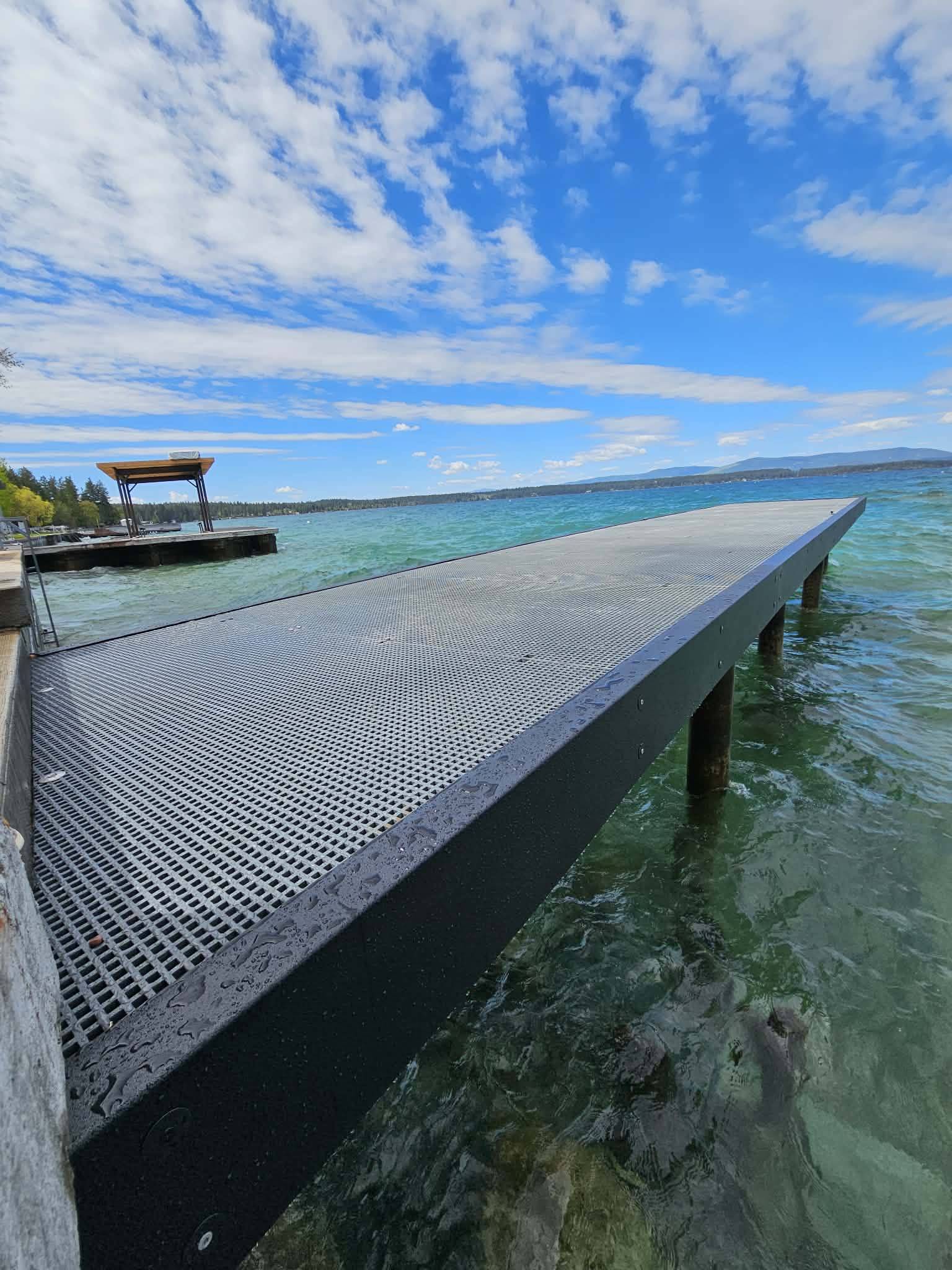 FRP dock with blue water and blue sky above.